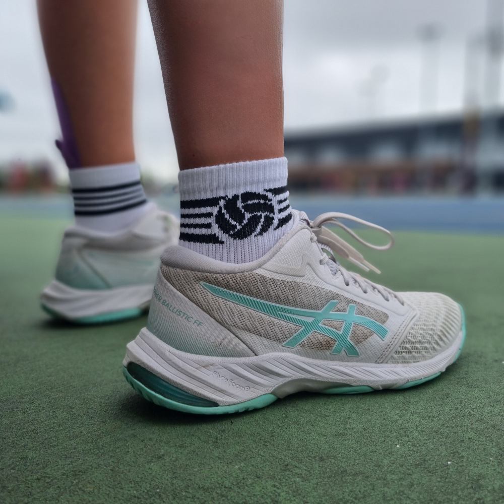 Netballer standing on side of court wearing Shoot netball socks