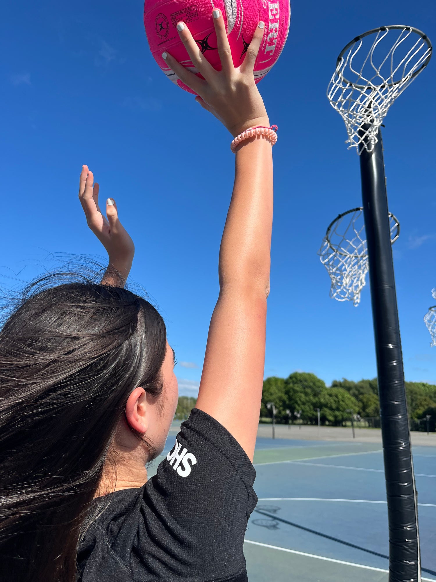 Young girl playing outdoor netball getting ready to shoot the ball into the hoop